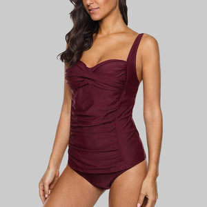 Maroon swimsuit worn by a model on a gray background