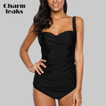 Load image into Gallery viewer, Woman wearing a black swimsuit with &#39;Charm Leaks&#39; branding on a gray background

