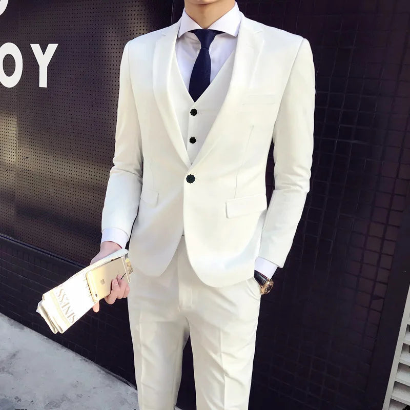 Man in a white suit with a blue tie holding a gold clutch against a dark background.