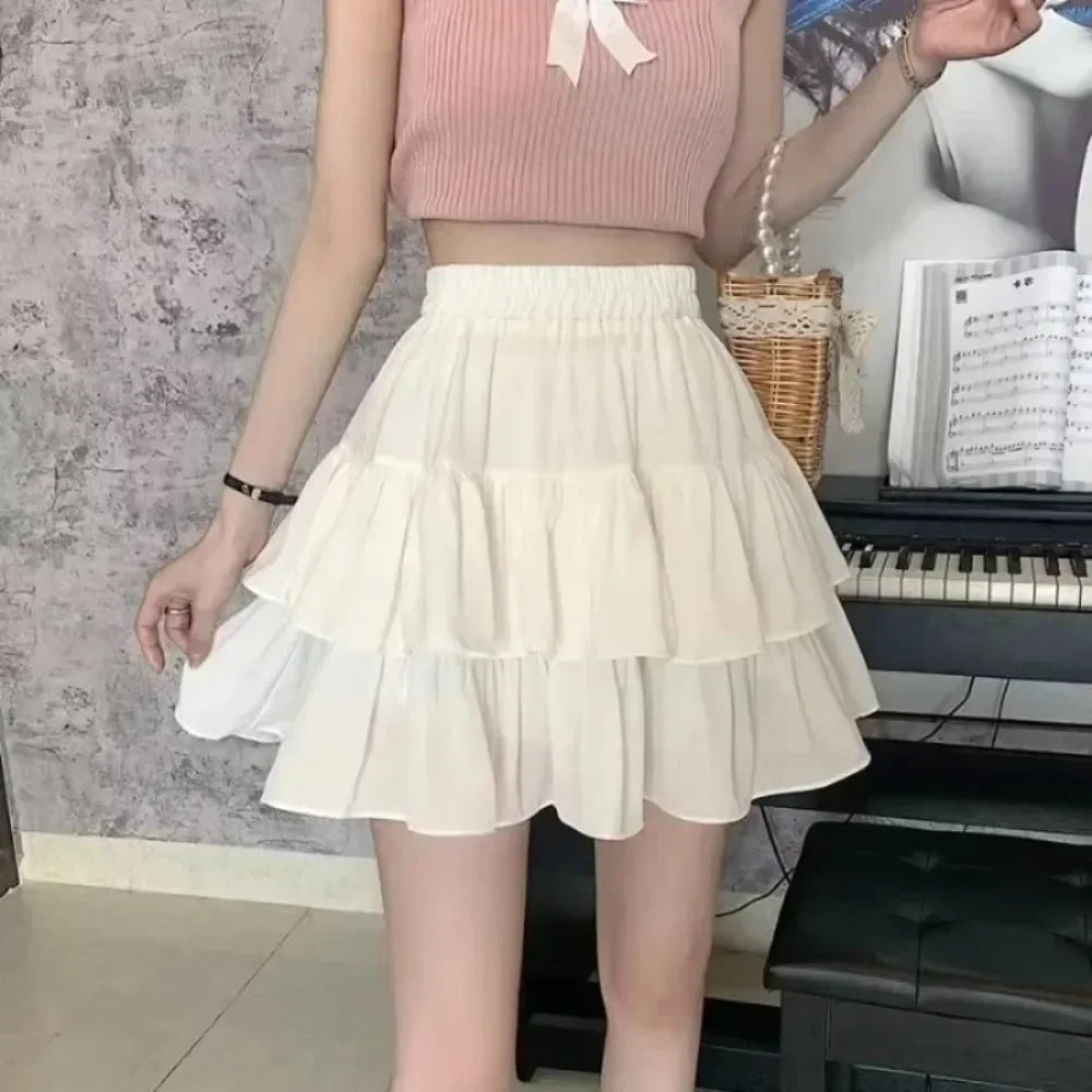 Person wearing a pink top and white skirt in front of a piano and music sheets.