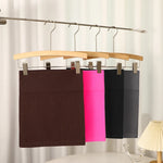 Load image into Gallery viewer, Three pairs of pants hanging on a wooden hanger against a neutral background.
