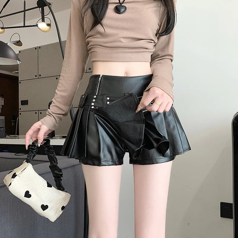 Person wearing a black leather skirt and holding a white bag with heart designs.