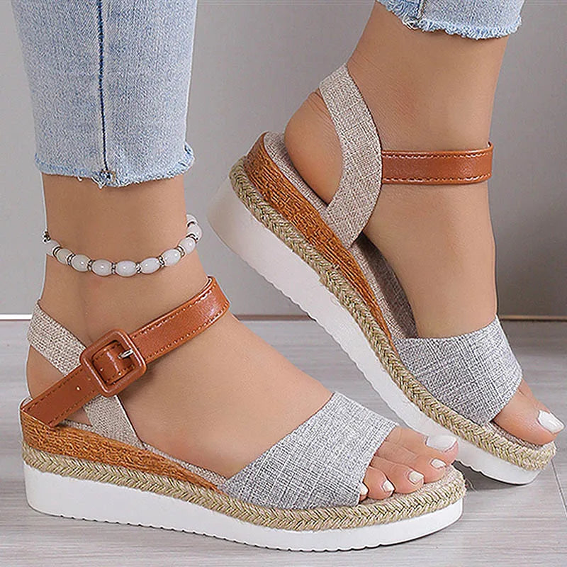 Woven sandals with brown straps and white soles worn by a person.
