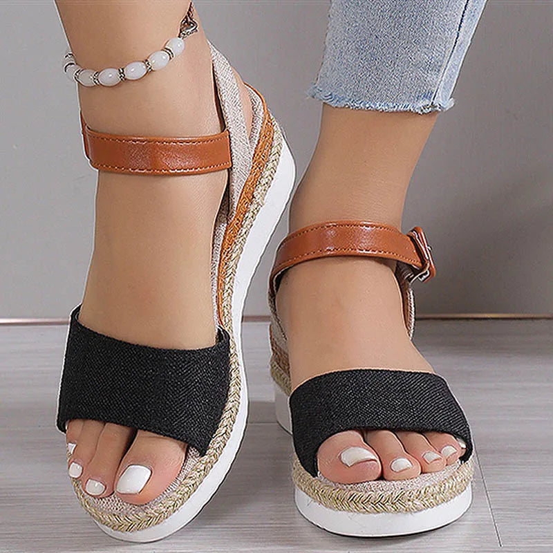 Black and brown wedge sandals on a neutral background