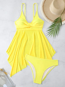 Yellow swimsuit with matching bottom, straw hat, and palm leaf on a light gray background