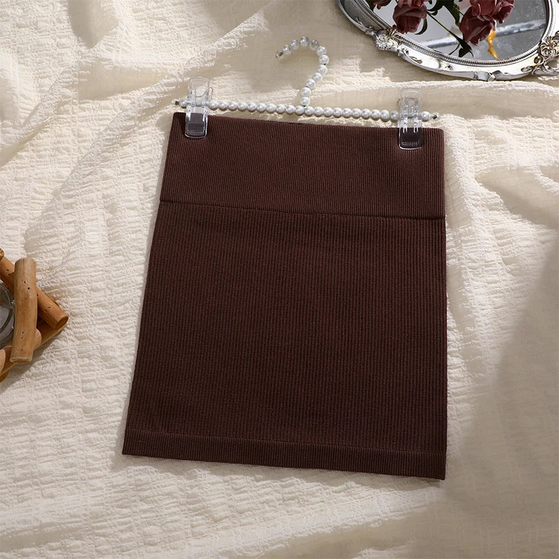 Brown skirt on a hanger against a textured white background