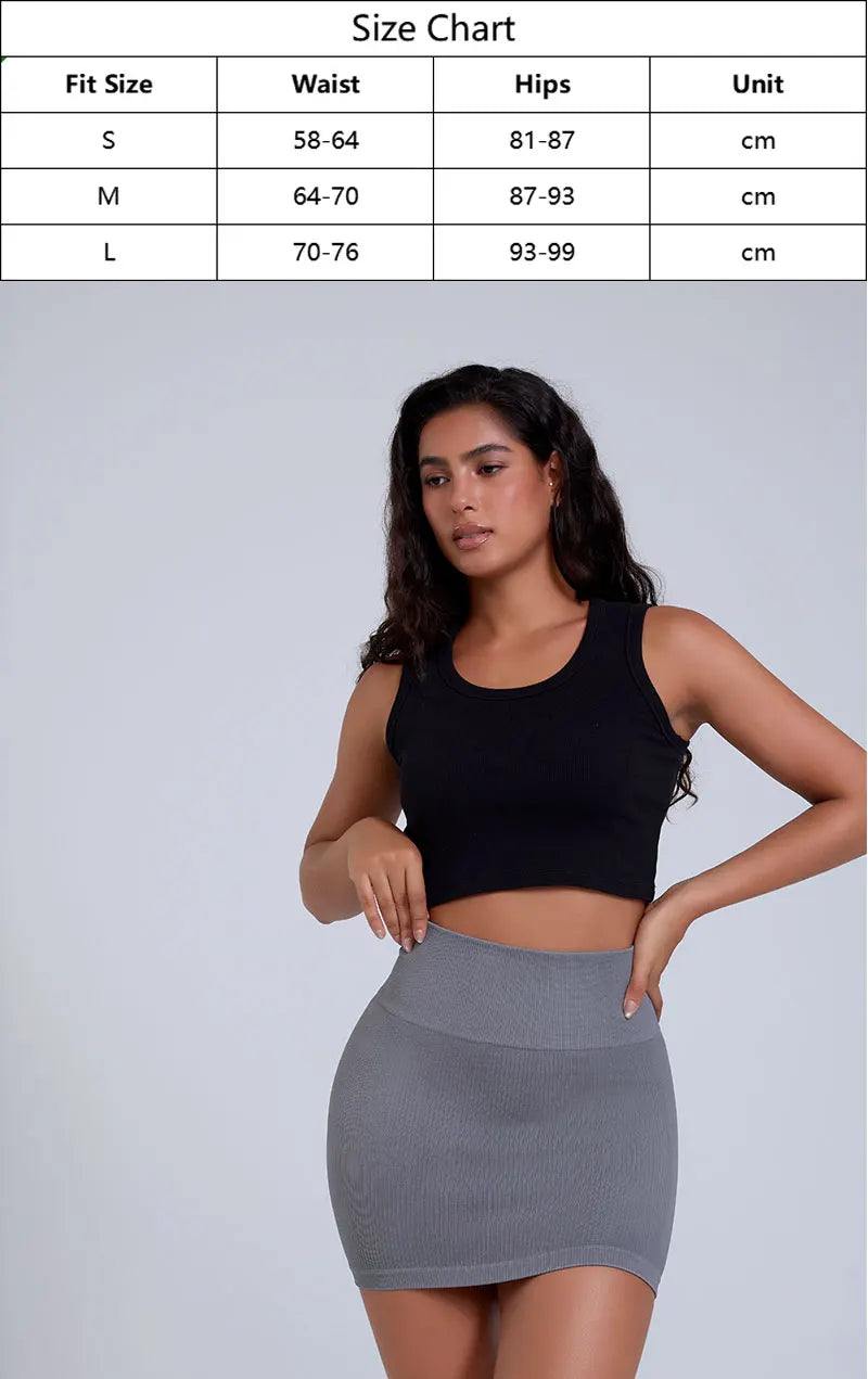 Woman wearing a black crop top and gray skirt with a size chart overlay on a white background